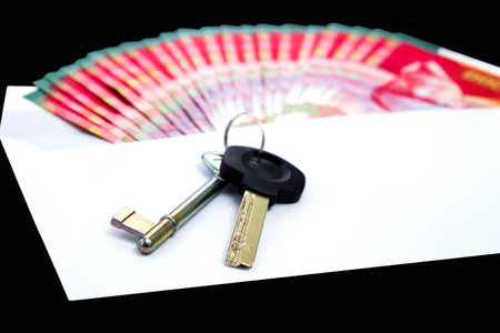 White envelope with money and key , bills of NIS 200 on a black background の写真素材