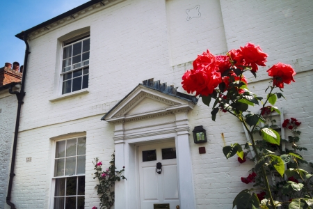 Red roses and English home の写真素材