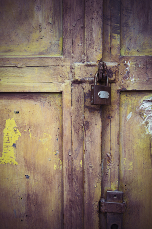 Weathered padlock and door with peeling paintの写真素材