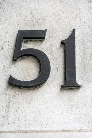 Number fifty one in dark figures on white wallの写真素材