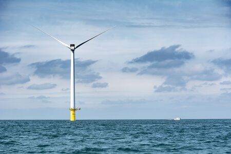 Wind turbine out at sea on sunny dayの写真素材