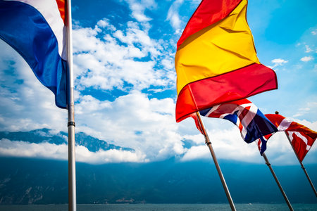 Flags of European nations flying over lake in Italyの写真素材