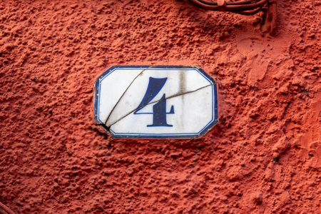 Number four door number on enamel plate on plaster wallの写真素材