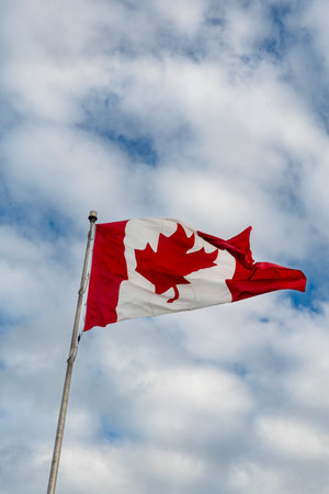 Canada flag with cloudy sky backgroundの写真素材
