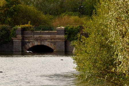 Stone built arch bridge carrying a road over a lakeの写真素材