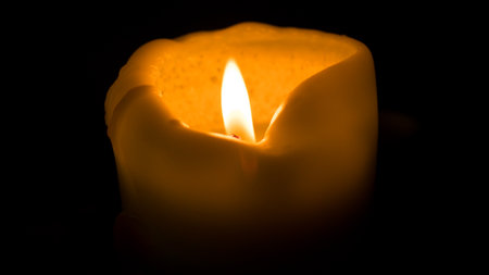 Burning candle on a black background, close-up, macroの写真素材