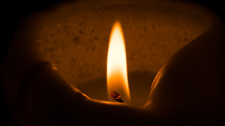 Close up of a burning candle in the shape of a heart.の写真素材