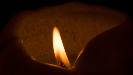 Close up of a burning candle on a black background. Selective focus.の写真素材