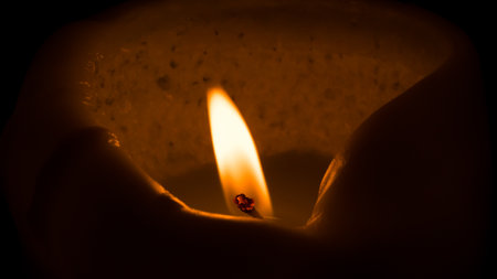 Close up of a burning candle in a dark room. Selective focus.の写真素材