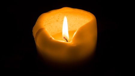 Burning candle on a black background, close-up, macroの写真素材