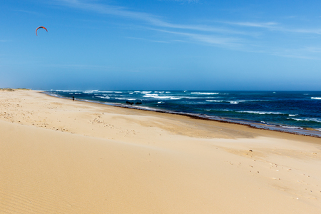 Side view of the sandy beach with a rough sea on the side.の写真素材