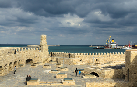 HERAKLION, GREECE - November, 2017:Tourists visiting old Venetian Fortress Koule in Heraklion, in the Rays of the setting sun against a stormy sky, Creteのeditorial素材