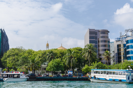 MALE, MALDIVES - November 17, 2017: in the foreground of the embankment in the abdomen with speedboats, ferry, against the backdrop of a mosque, skyscrapers and palms, Indian Ocean, Male, Maldivesのeditorial素材
