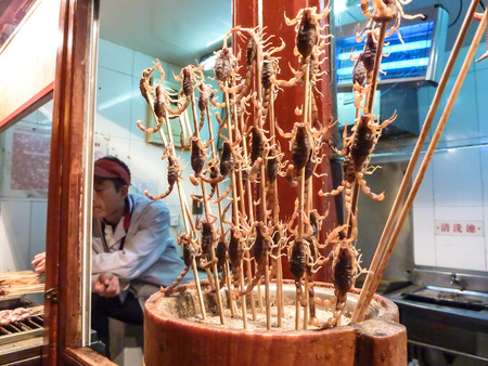 BEIJING, CHINA - October 13, 2013: Selective focus - fried scorpions on sticks for sale in mini market, Wangfujing Snack Street, popular shopping place for tourists and local, Beijing, Chinaのeditorial素材