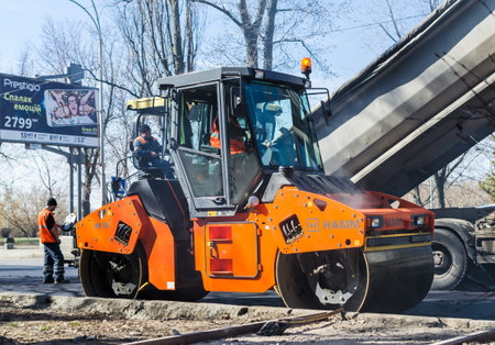 KIEV, UKRAINE - March 29, 2017: Road road works in the Rusanovka district. Kiev, Ukraine. People and...