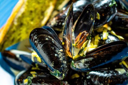 Mussels with home cooked garlic bread and sauce in a blue dishの写真素材