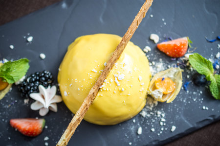 Ice cream with yellow lemon glaze and fresh berriesの写真素材