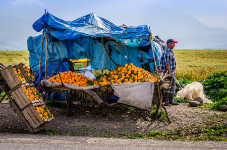 Meknes, Morocco - April 08, 2015. Seller of the fresh oranges by the road with half broken standのeditorial素材