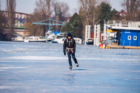 Prague, Czech republic - February 14, 2021. Single middle age man ice skating on frozen riverのeditorial素材