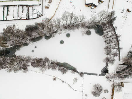 Nupaky, Czech republic - February 09, 2021. Aerial view of small frozen pond in winter under the snowのeditorial素材