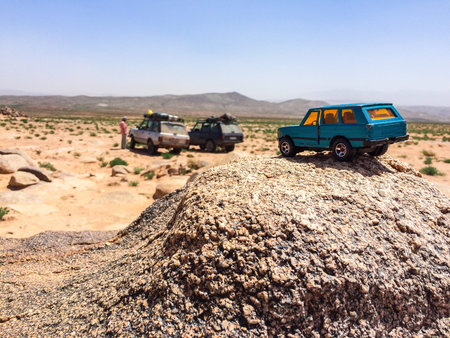 Zaida, Morocco - April 10, 2015. Toy car in terrain as a comparison of real cars of Range Rover...