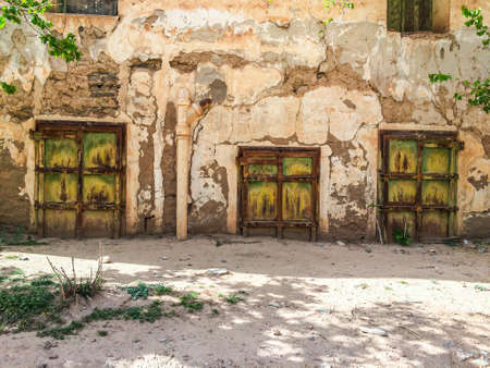 Aouli, Morocco - April 10, 2015. Green rusty doors of abandoned house, partly buried by sandのeditorial素材