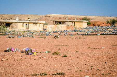 Aouli, Morocco - April 10, 2015. Huge amount of rubbish dispersed in desert between abandoned ruins