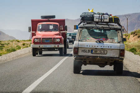 Midelt, Morocco - April 11, 2015. Fully loaded off road car on road trip passing by red vintage truckのeditorial素材