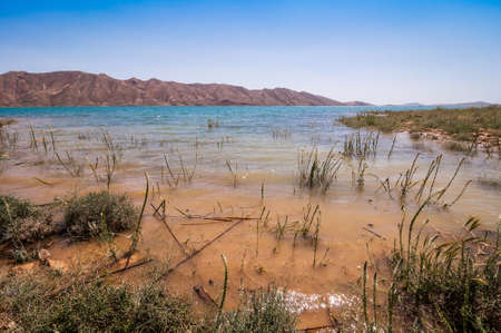 Turquoise blue water in Barrage Al-Hassan Addakhil in dry nature near Errachidia in Moroccoの写真素材