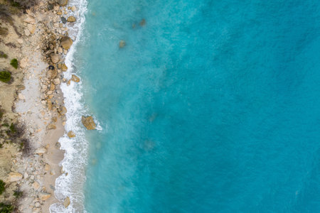 Straight down view on waves on rocky shore by Bunec Beach area in Summer 2022, Albaniaの写真素材