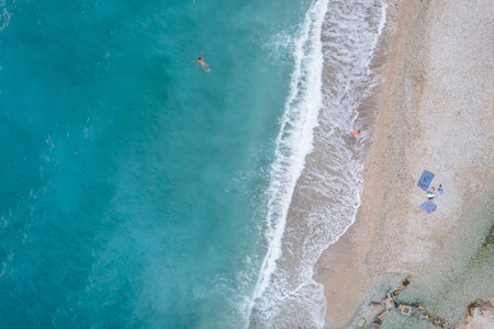 Straight down view on waves and shore of small stones by Bunec Beach area in Summer 2022, Albaniaの写真素材