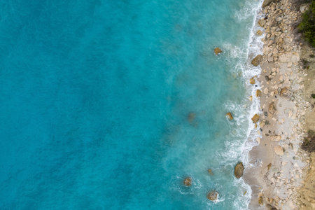 Straight down view on waves on rocky shore by Bunec Beach area in Summer 2022, Albaniaの写真素材