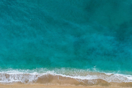 Straight down view on waves and shore of small stones by Bunec Beach area in Summer 2022, Albaniaの写真素材
