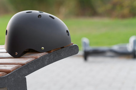 Black safety helmet and two wheel on the background