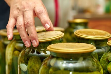 Preservation of fresh house cucumbers in glass jars. Closeup, selective focusの素材 [FY310148982677]