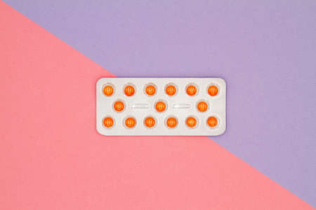 Top view of orange pills in blister on a colored background. Healthcare conceptの写真素材
