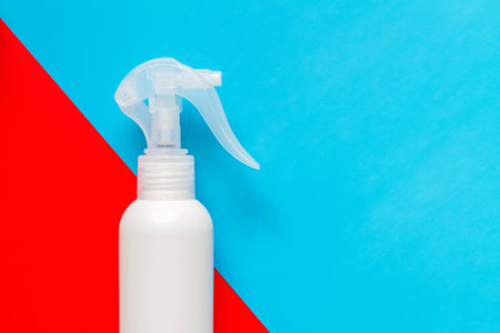 Spray disinfectant on a blue-red background for viruses prevention