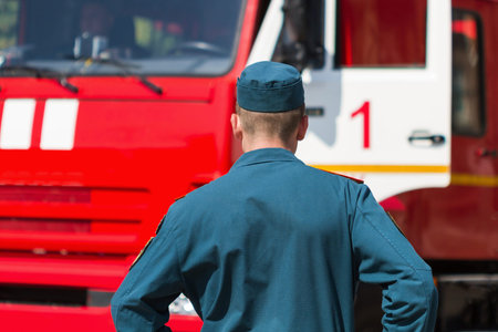 Rescuer near the fire truck. Back view