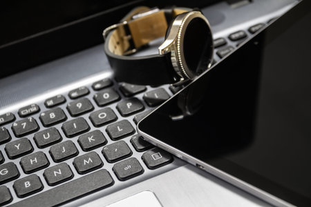 Modern tablet and smart watch is on the laptop. Closeup, selective focus