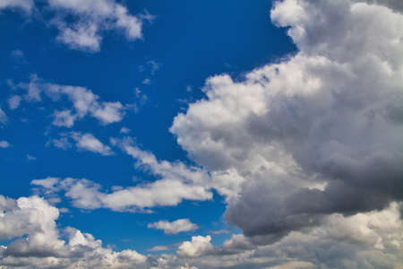Cloudscape. Blue sky and gray clouds. Sunny day. Cumulus clouds.の写真素材