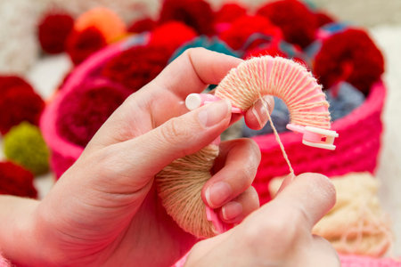Handmade pompons. The process of making pompons from threads by woman