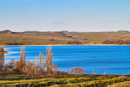 Landscape. Pond, slagheaps, grass, sky.の写真素材