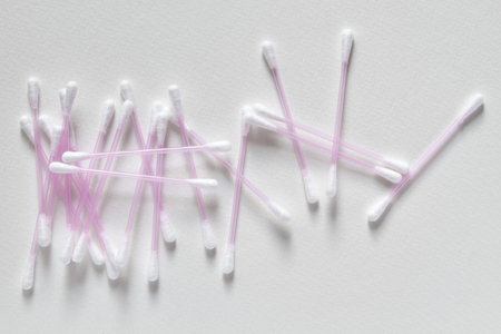 A group of ear swabs or cotton ear sticks on the light background. Ear care cjncept. Closeup