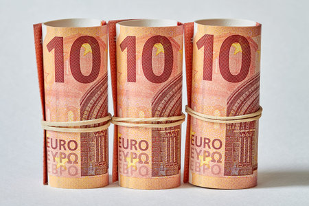 Ten Euro bill rolled up as a tubule. Ten Euro banknote details in a macro shot. Closeup, selective focusの写真素材