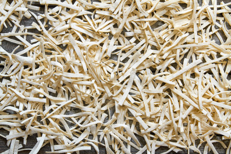 Handmade noodles are dried on a wooden board. Top view