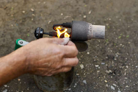 A man kindles a flame at the old rusty blowtorch.の写真素材
