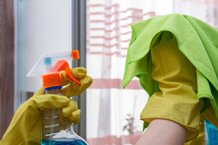 Hands with a duster and detergent cleaning the mirrorの写真素材