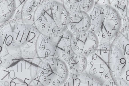 Background from set of white analog round office clocks of different sizes showing various timeの写真素材