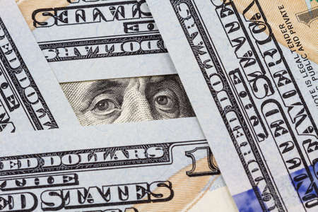 Benjamin Franklin's eyes between hundred dollar billsの写真素材
