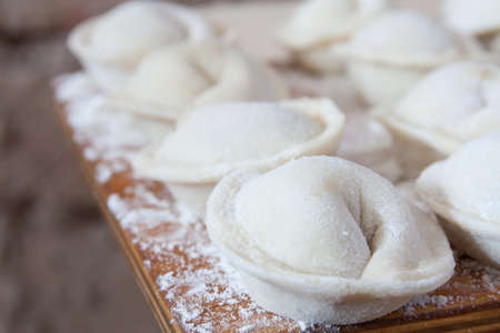 Process of making homemade pelmeni on wooden board. Traditional dish of Russian cuisine. Selective focusの写真素材